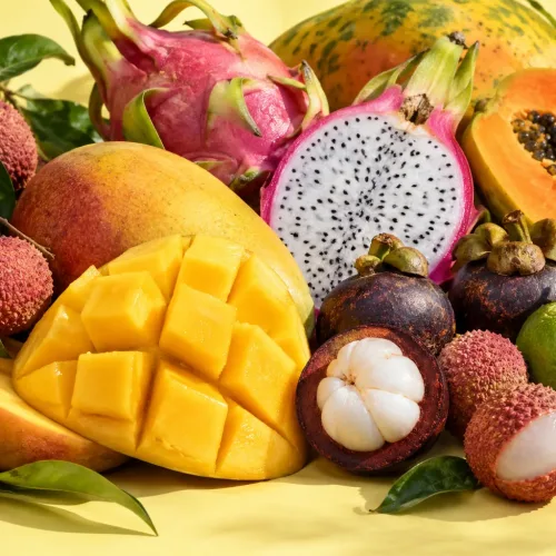 A colourful still-life of mango, dragon fruit, lychees, mangosteen, lime and papaya